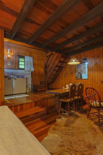 a kitchen and dining room with a table and chairs at Pousada Cantos e Contos in Monte Verde