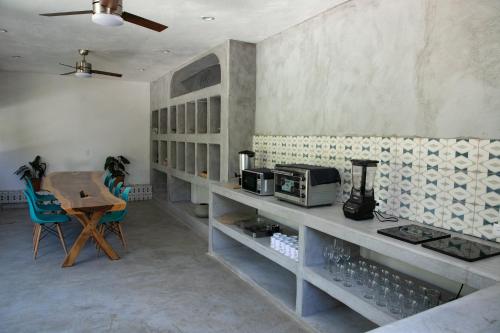 a kitchen with a counter with a table and a microwave at Casa Kâi in Brisas de Zicatela