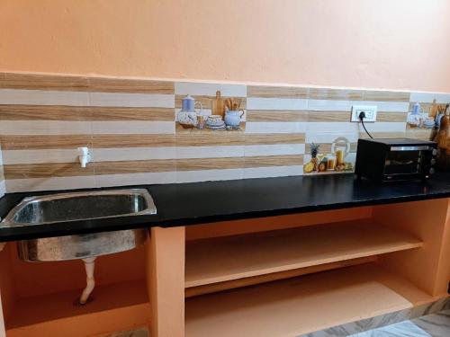 Una encimera de cocina con fregadero y microondas. en Smiley HomeStay at Chidambaram, en Chidambaram