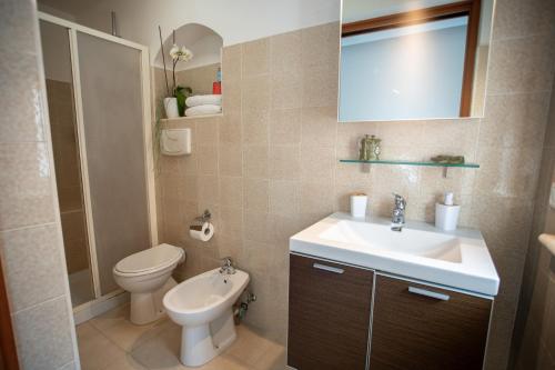a bathroom with a sink and a toilet and a mirror at Arco di Luna Piano 2 in Trani