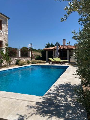 a swimming pool in front of a house at Villa Karmen in Barbat na Rabu