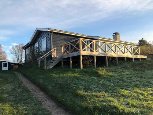 a house on a hill with a large deck at Nice Summer House With Sea View in Jægerspris