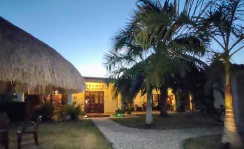 a building with palm trees in front of it at Royale Manor in Corozal