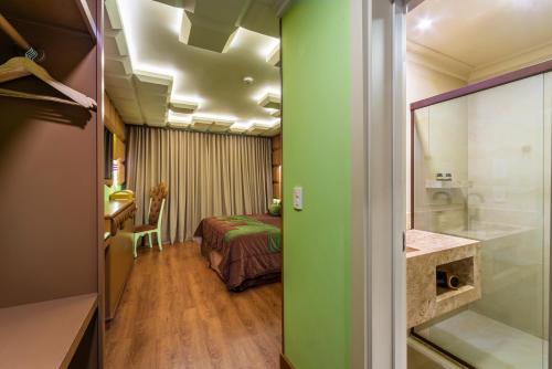 a room with a bed and a room with a bathroom at Chocoland Hotel Gramado in Gramado