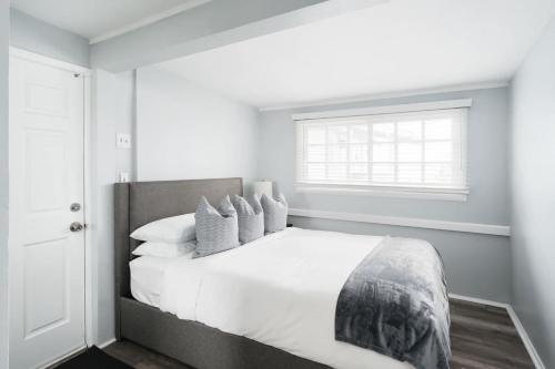a bedroom with a bed with white sheets and pillows at Bankers Hill Chic Roomy Home Near Airport in San Diego