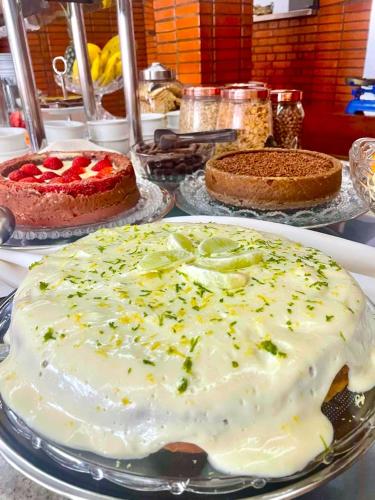 un tavolo ricoperto di torte e dolci su piatti di Hotel Verdes Mares a Ouro Branco