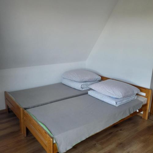 a bed in a room with two pillows on it at Wynajem Pokoi Maria Sowińska in Biały Dunajec