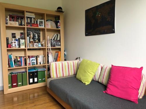 a living room with a couch with colorful pillows at Les Hauts du Tertre Notre Dame in Saint-Brieuc