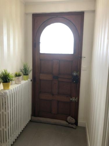 a wooden door with a window and two potted plants at Les Hauts du Tertre Notre Dame in Saint-Brieuc