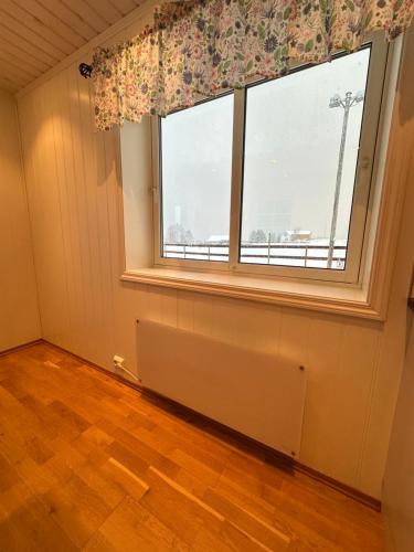 an empty room with a large window with a radiator at Marisletta farm - house by the sea in Tromsø