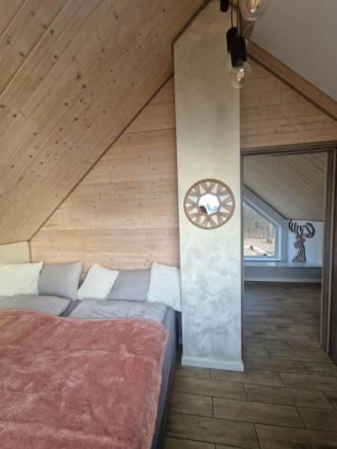 a bedroom with a bed and a clock on a wall at Chill Chaty in Tarnobrzeg