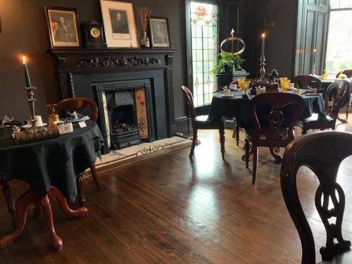a dining room with tables and chairs and a fireplace at 23 Mayfield in Edinburgh
