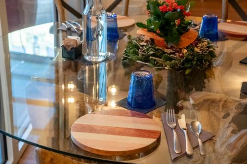 a glass table with a wooden board and flowers on it at San Anton Hotel in Trecastagni