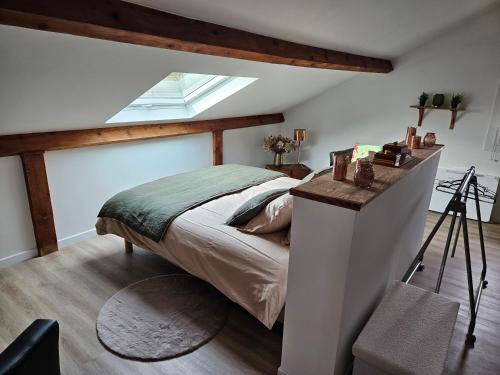 a bedroom with a bed and a skylight at Les chambres de Luciole in Asnières-lès-Dijon