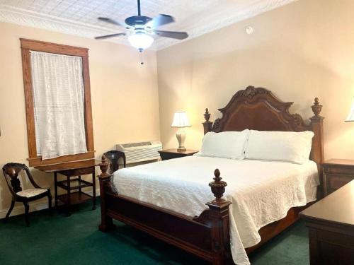 a bedroom with a bed and a ceiling fan at The Eastland Historic Hotel- Imperial Room in Eastland