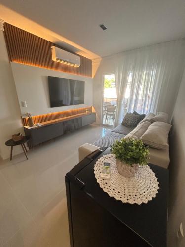 a living room with a couch and a table at Lindo apartamento próximo do mar novinho in Bombinhas