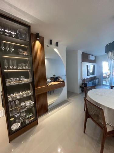 a dining room with a table and a kitchen at Lindo apartamento próximo do mar novinho in Bombinhas