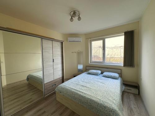 Un dormitorio con una cama y una ventana grande. en Ssenyange Sea View Apartment, en Varna