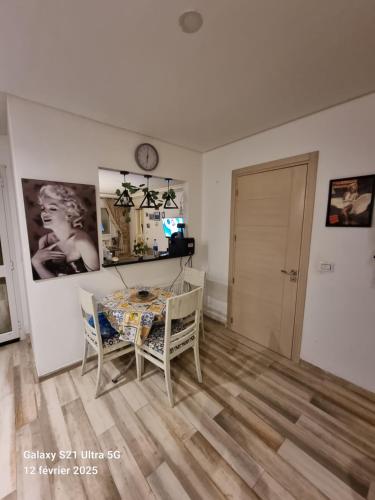 a living room with a table and chairs and a clock at Ghamarth Mikonos in Gammarth