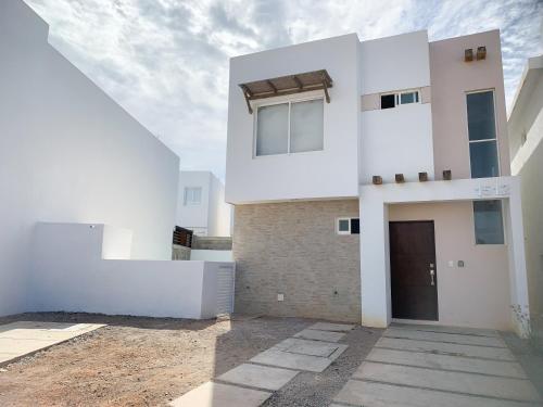 a white house with a door in a yard at Casa con alberca privada en Almarena in Mazatlán
