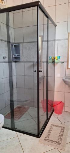 a glass shower in a bathroom with a toilet at Hospedagem Familiar Yamane in Ilha Comprida