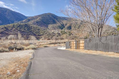 an empty road with a fence and mountains in the background at Mountain Views Minimalist California Studio in Frazier Park