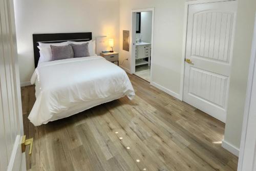 a bedroom with a white bed and a wooden floor at 1 - Serenity Suite - 1 - Reese Tower in Tulsa