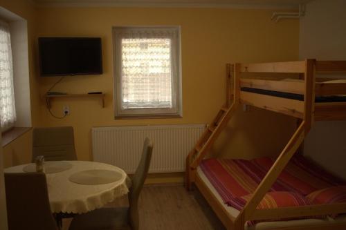 a small room with a bunk bed and a table and a desk at Privát Zuzana in Jablonec nad Jizerou