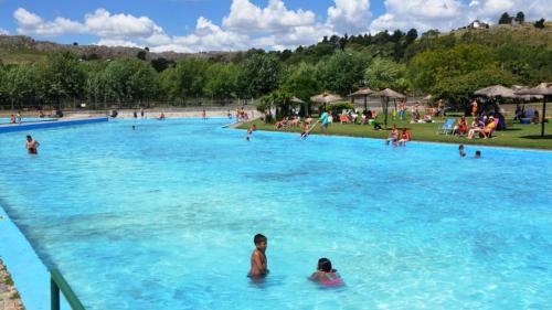 a large swimming pool with people in the water at Casa Alvear - Bed & Breakfast in Tandil