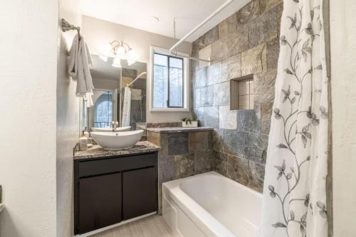 a bathroom with a tub and a sink and a bath tub at The Affordable Family Fun House- Ping Pong, Pool Table, Darts in Post Falls