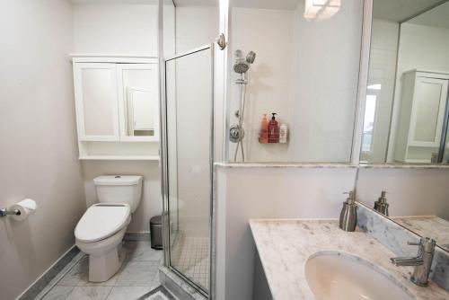 a bathroom with a toilet and a sink and a shower at 3BR Urban Gem with Scenic Balcony Views in Toronto