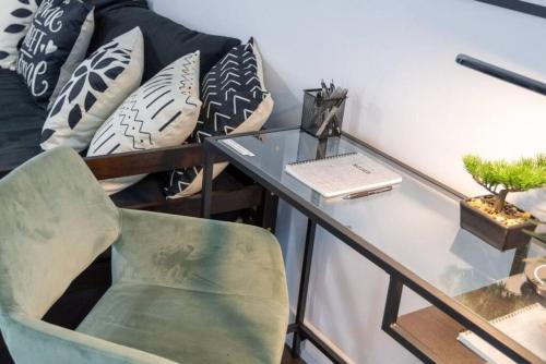a desk with a chair next to a couch with pillows at Exquisitely Furnished 1BR Suite in DWTN Toronto in Toronto