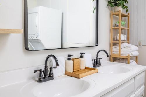 lavabo con 2 grifos y espejo en Cozy Duplex w King Bed 2 Full, en Maryville