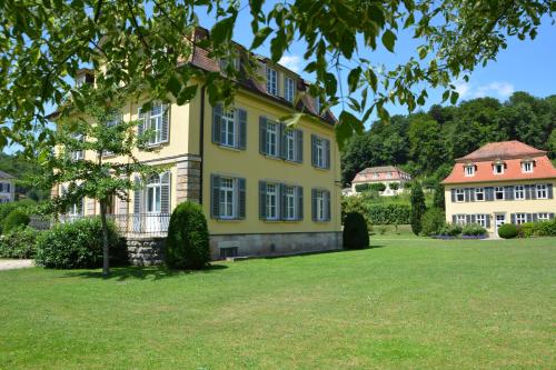 a large yellow house with a green yard at Villa Widder - Boutiquehotel in Staatsbad Brückenau
