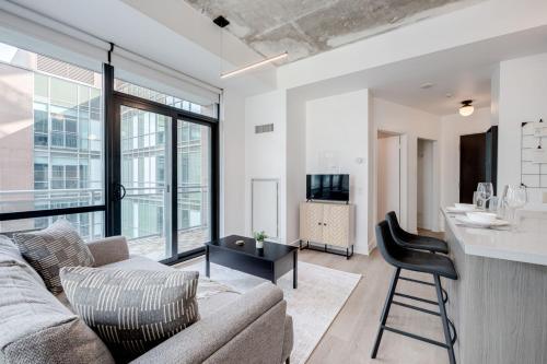 a living room with a couch and a bar at Studio Gem in the lovely Waterfront Communities in Toronto