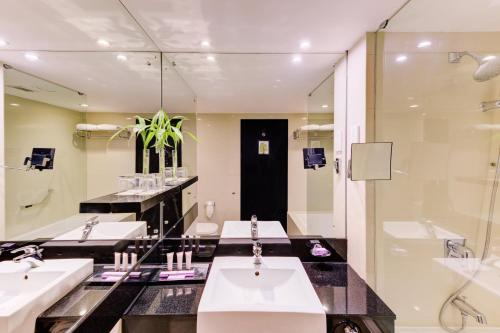 a bathroom with two sinks and a shower at Cinnamon Lakeside in Colombo