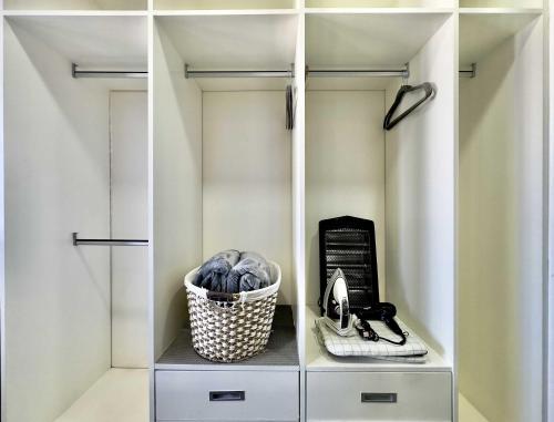 a walk in closet with white cabinets and a basket at Tijuana Condo at Avenida Revolución 9th floor in Tijuana
