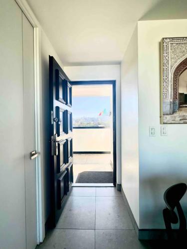a hallway with an open door with a view of the ocean at Tijuana Condo at Avenida Revolución 9th floor in Tijuana