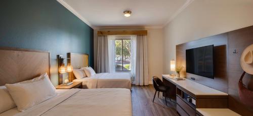 a hotel room with two beds and a television at Ayres Hotel Chino Hills Ontario in Chino Hills