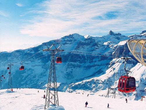 a ski lift with skiers on a snow covered mountain at Luxuse Ferienwohnung Flüe 11 in Leukerbad