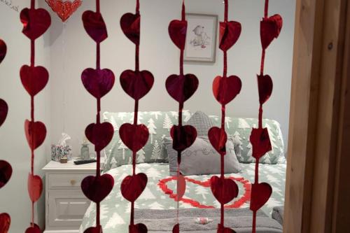 a bunch of red hearts on a wall in a bedroom at HotTub-Nature-FamilyFriendly-WiFi-Parking in Ballykelly