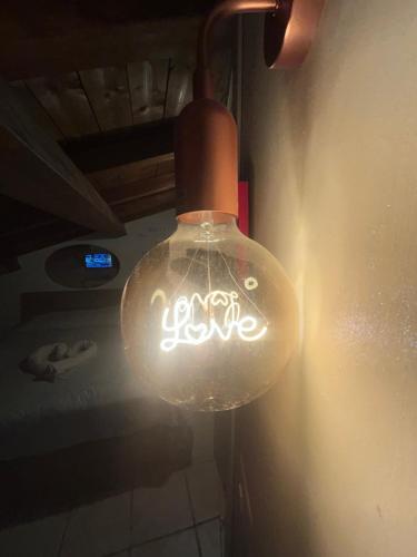 a glass light bulb hanging from a wall at Ale e Nau in Rome
