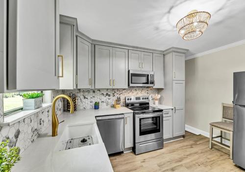 a kitchen with white cabinets and stainless steel appliances at 15% off! Front porch w/ Wi-Fi & Private Parking in Gibsonville