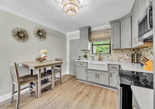 a kitchen with white cabinets and a wooden table at 15% off! Front porch w/ Wi-Fi & Private Parking in Gibsonville
