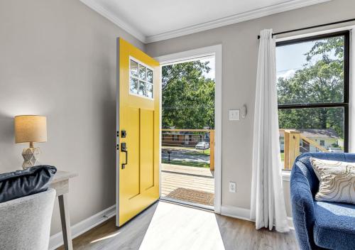 a yellow door in a living room with a blue couch at 15% off! Front porch w/ Wi-Fi & Private Parking in Gibsonville