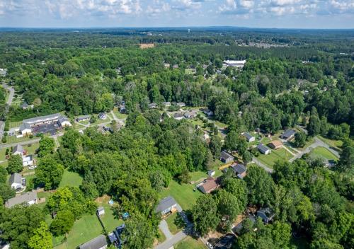 an overhead view of a subdivision of houses and trees at 15% off! Front porch w/ Wi-Fi & Private Parking in Gibsonville
