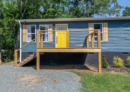 a tiny house with a yellow door and a porch at 15% off! Front porch w/ Wi-Fi & Private Parking in Gibsonville