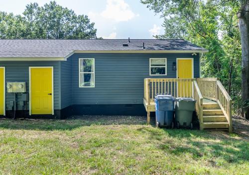 a house with yellow doors and two trash cans at 15% off! Front porch w/ Wi-Fi & Private Parking in Gibsonville