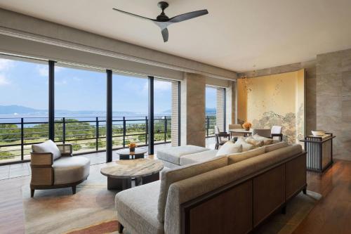 a living room with a large couch and a large window at The Ritz-Carlton Okinawa in Nago