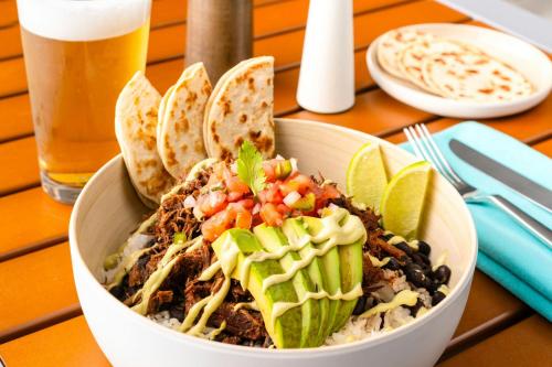 a bowl of food on a table with tacos and a drink at Element Melbourne Oceanfront in Melbourne